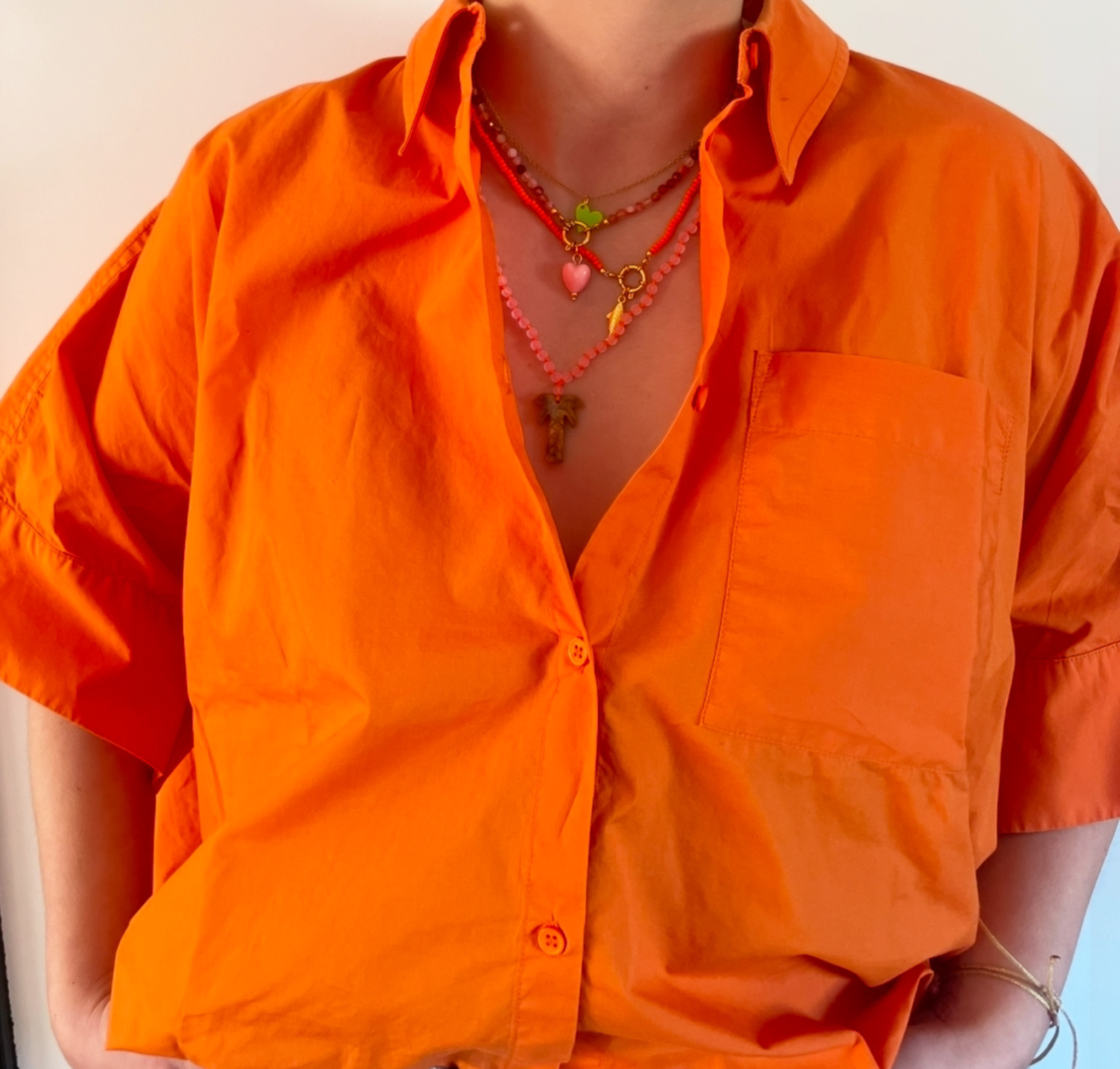 Bert Kettingenset in de kleur Oranje. Een mix van palmboomketting, glaskralen ketting en gem ketting. Met verschillende bedels.