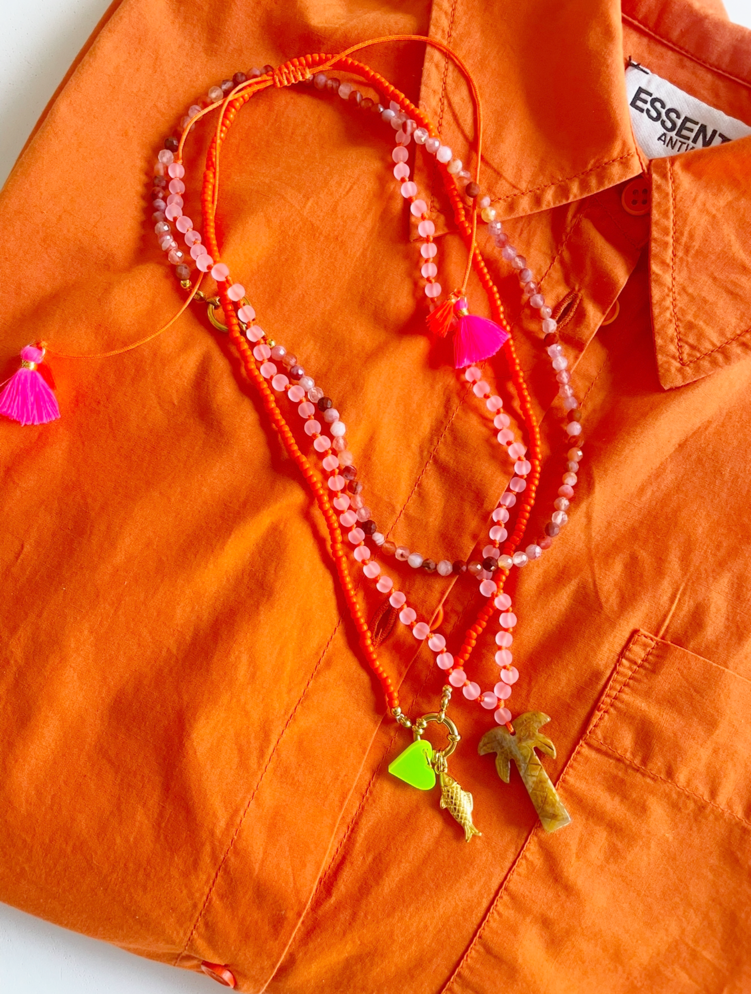 Bert Kettingenset in de kleur Oranje. Een mix van palmboomketting, glaskralen ketting en gem ketting. Met verschillende bedels.