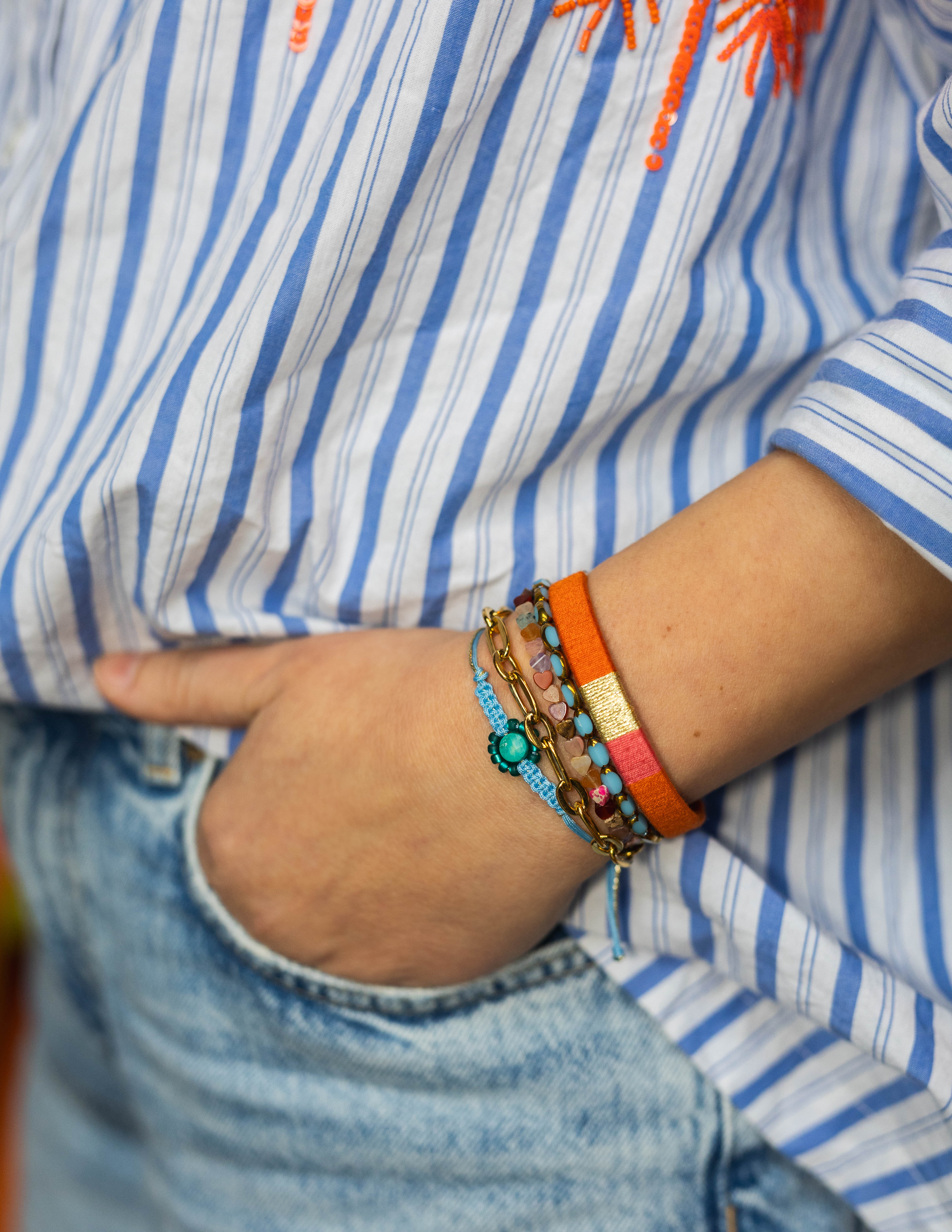 Hand in zak met een armbandenset van Bert Sieraden in Oranje en Blauwe tinten.