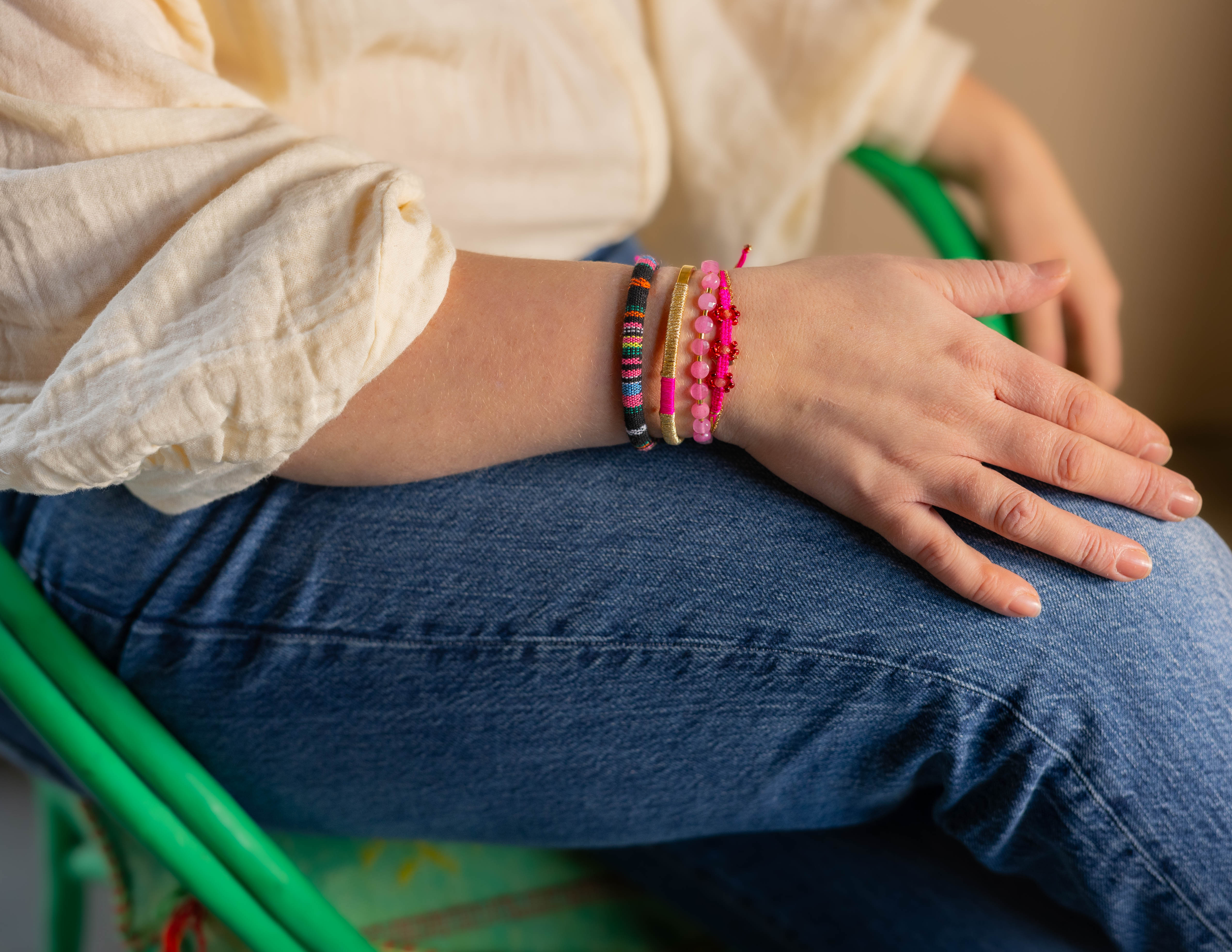 Foto met arm met armbandenset van Bert Sieraden in de kleuren roze, Goud en Zwart.