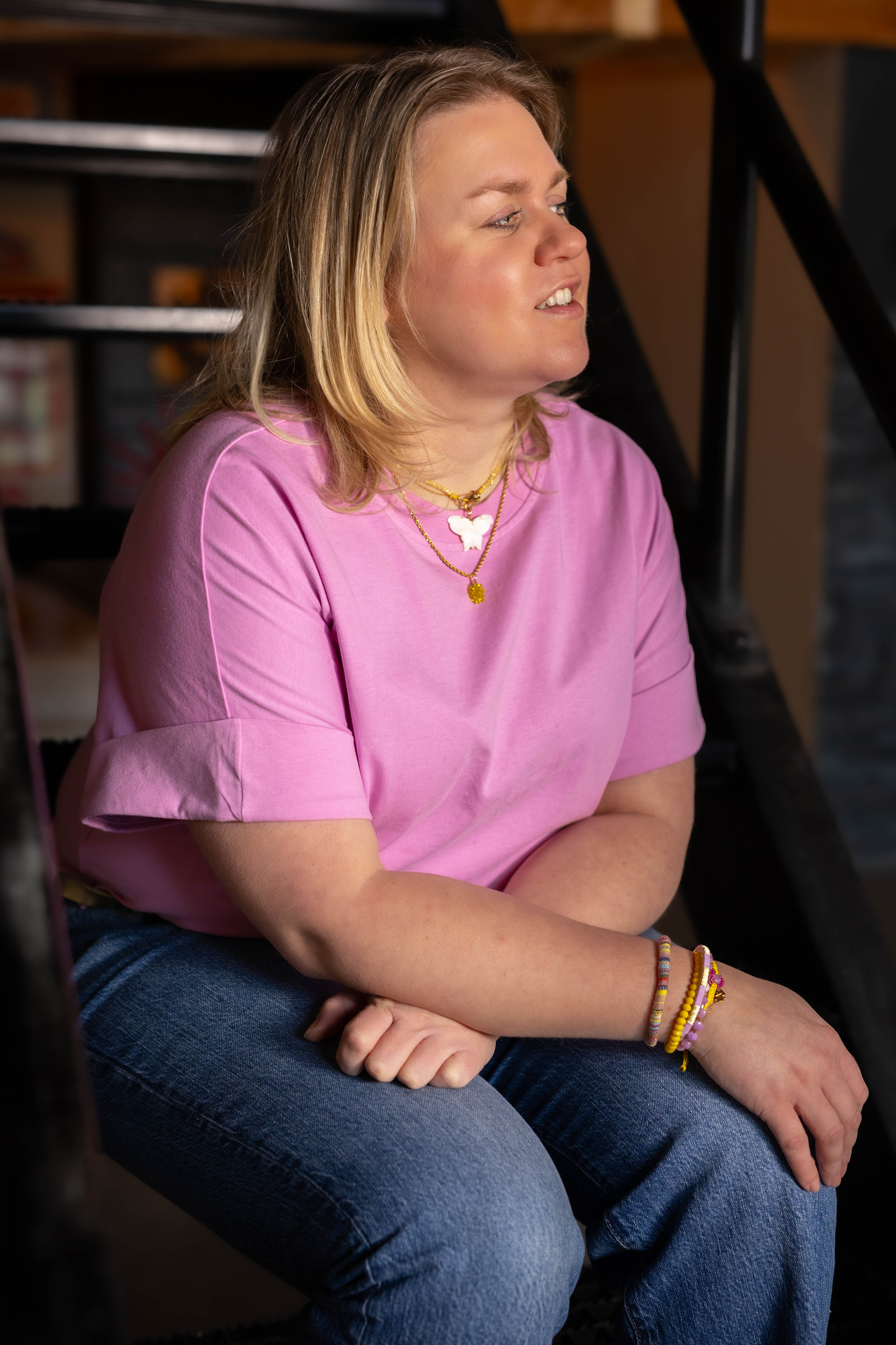 Model met roze shirt en armbandenset van bert sieraden in geel en roze.