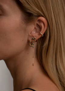 Je ziet oorbellen van Bobby Rose Jewelry in een oor. Het zijn meerdere oorbellen van swarovski en goud.