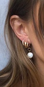 Dit is een foto van een persoon die oorbellen van Bobby Rose Jewelry draagt met wit swarovski en Goud.