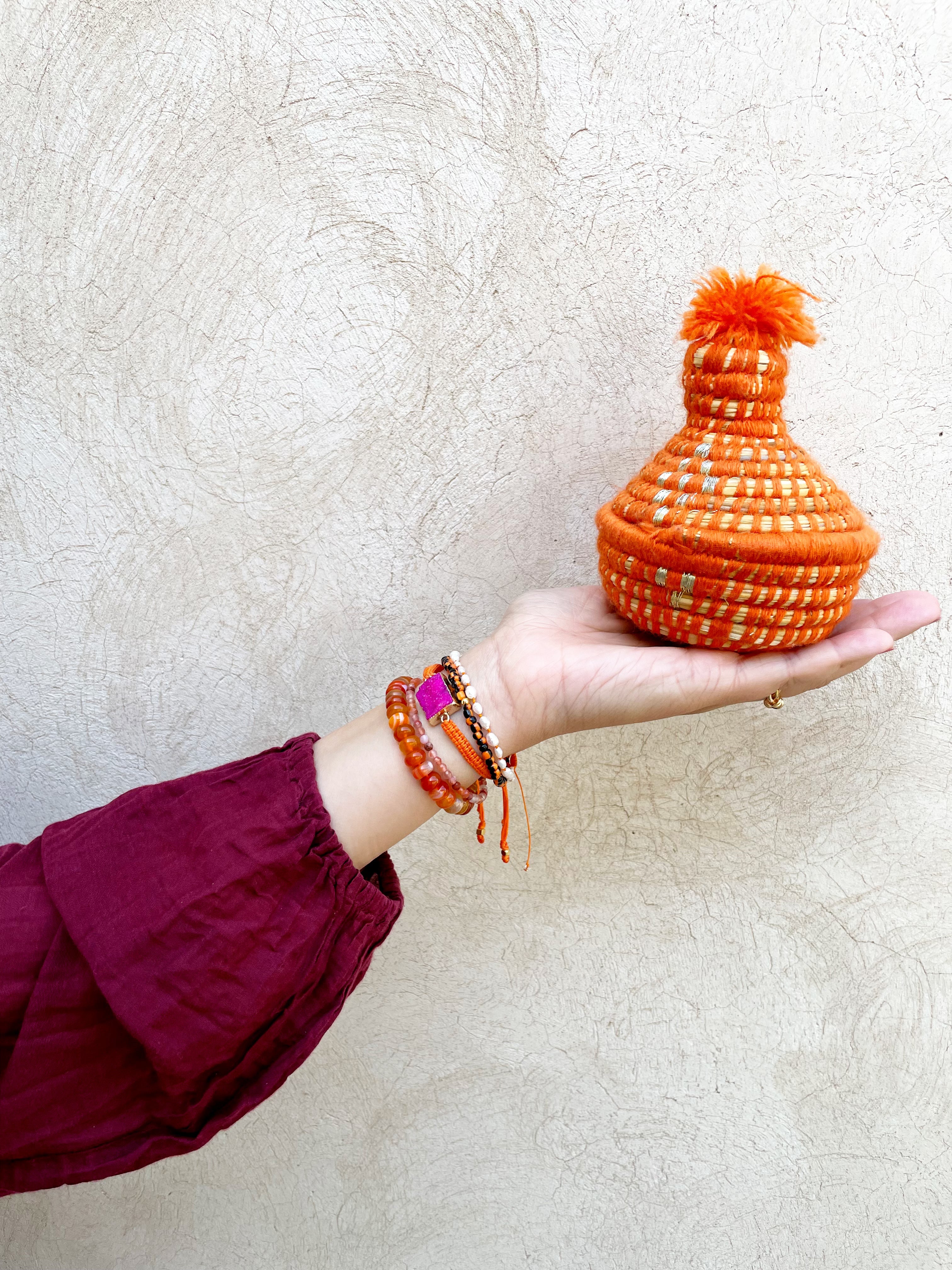 marokkaans mandje met armbandjes in de kleuren roze en oranje.
